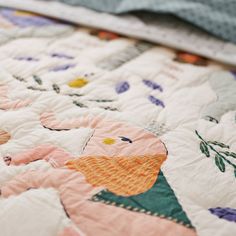 an elephant themed quilt is laying on the bedding with it's head turned to the side