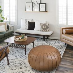 a living room with couches, chairs and pictures on the wall above them in various frames