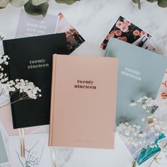 three different colored books sitting next to each other on top of a marble countertop