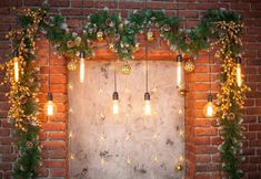 a brick wall decorated with lights and greenery