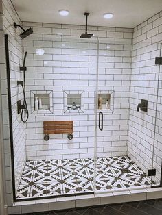 a bathroom with black and white tiles on the floor, shower head, and toilet