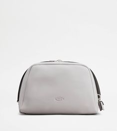 Characterized by maxi zip pulls, straps that elegantly cover the zip when closed, Tod's Darsena pouch bag is defined by essential and feminine lines. Featuring the Tod's logo stamped on the front and a back pocket, it comes with a wrapped side padlock, a sophisticated distinctive trait. Here in fine natural-grained calfskin leather, this is a model with a distinctly urban nature, named after the city of Milan. Area Codes, Urban Nature, Gift Boutique, Logo Stamp, Leather Items, Pouch Bag, Trainers Women, Brown And Grey, Calf Skin