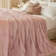 a bed with a pink blanket on top of it