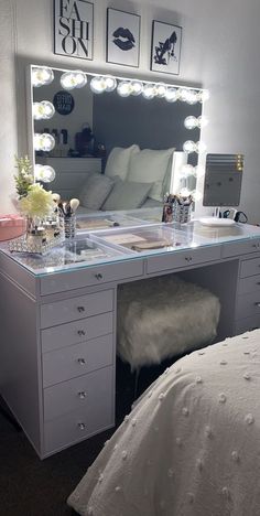 a bedroom with a bed, mirror and lights on it's sides in front of a window