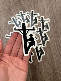 a person holding up a sticker with the shape of a cross and a horse on it