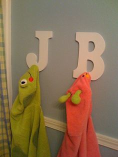 two towels are hanging on the wall next to each other in front of letter j