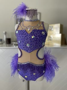 a mannequin with purple feathers and beads on it