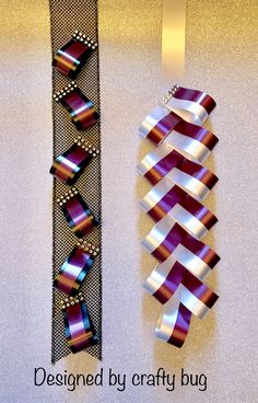 two pieces of ribbon are hanging on the wall next to each other, one is purple and silver