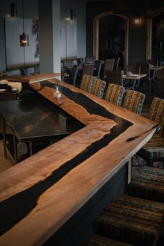 an empty restaurant with chairs and tables in the center, along with a long wooden table