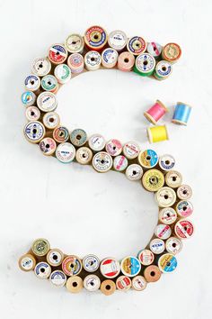 the letter s is made out of many different types of spools of thread