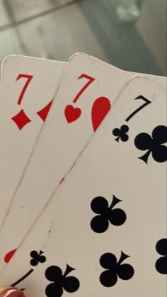 four playing cards being held up in the air