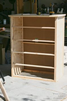 an unfinished bookcase sitting in the middle of a garage