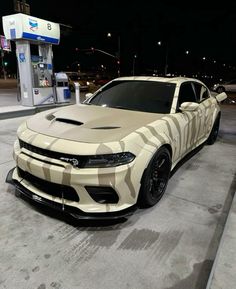 a white camo car parked in front of a gas station