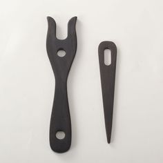 two pieces of wood with holes in the middle and one piece cut out to look like scissors