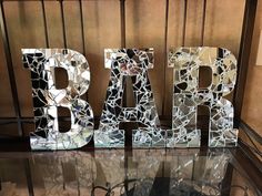 the letters are made out of broken glass and have been placed on top of a table