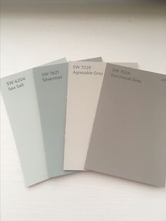 four different shades of paint sitting on top of a white table next to each other