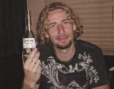 a man holding up a beer bottle in his hand