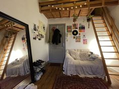 a bedroom with bunk beds and ladders on the ceiling, in front of a mirror