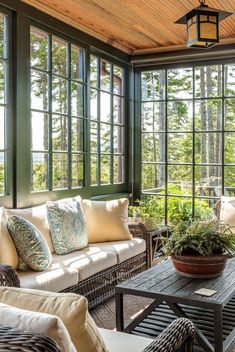 a screened porch with wicker furniture and large windows