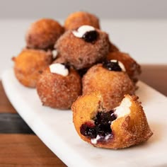 small pastries with blueberries and cream filling on a white plate