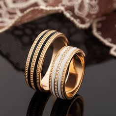 two gold rings with black and white bands