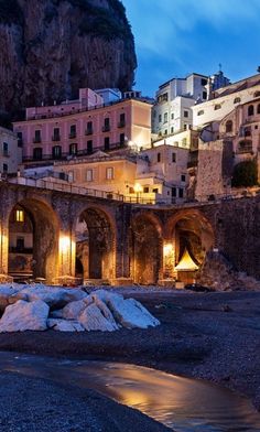 an old town lit up at night with mountains in the background