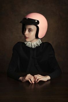 a woman sitting at a table with a helmet on her head