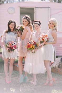 the bridesmaids are all wearing short dresses and holding bouquets