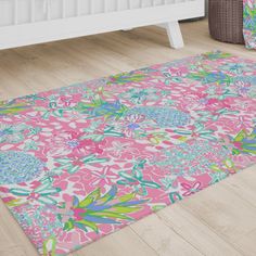 a pink and green floral area rug on the floor