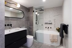 a bathroom with a tub, toilet and sink in it's center wall is shown