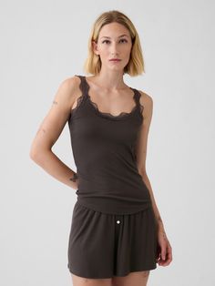 Made with 68% LENZING™ TENCEL™ Modal, a wood-based fiber produced from trees harvested from sustainable forests where 99% of the raw material comes from certified or controlled sources.  LENZING™ and TENCEL™ are trademarks of Lenzing AG.  Soft ribbed knit pajama tank top.  Round neck, scoop back with lace details.  Sleeveless.  Lace tank straps.  Slim fit that hugs the body.  Hits at the hip.  Models wearing Gap Pajama Tank Top, 2024 Recap, Support People, Gender Equality, Top Round, Lace Tank, Raw Material, Second Skin, New Woman