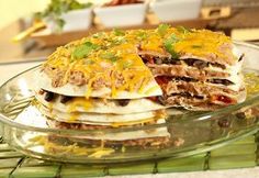 a stack of quesadillas sitting on top of a glass plate covered in cheese