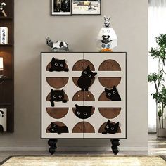 a cabinet with cats on it in a living room next to a rug and pictures