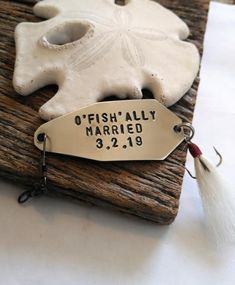 a fishing hook with a fish's ally on it and a name tag attached to it