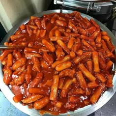 a large metal pan filled with food covered in sauce