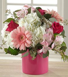 a pink vase filled with white and pink flowers