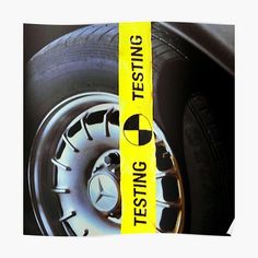 a yellow sign that says testing on the side of a black car's tire