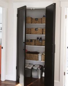 an open pantry door with baskets in it