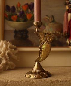 a gold candle holder sitting on top of a table