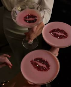 three glasses filled with liquid sitting on top of each other in front of a woman's face