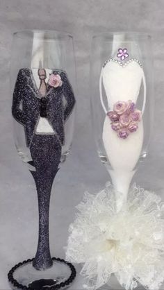 two wine glasses decorated with bride and groom figurines, one holding a bouquet of flowers