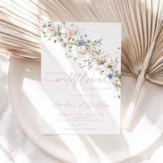 an elegant bridal shower with flowers and leaves on the cover is displayed next to a fan