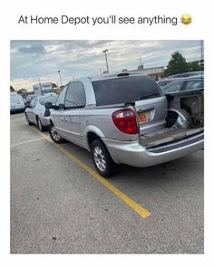 the back end of a silver truck parked in a parking lot next to other cars