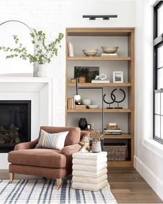 a living room filled with furniture and a fire place in front of a white brick wall