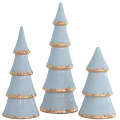 three white ceramic christmas trees with gold trim