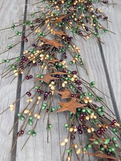 an arrangement of berries and leaves on a wooden table