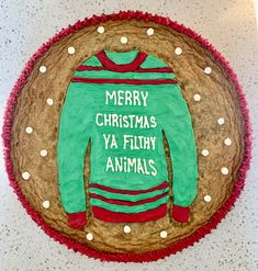 a cake decorated to look like a sweater with the words merry christmas ya filthy animals on it