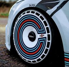 a close up view of the front tire cover on a sports car with colorful stripes