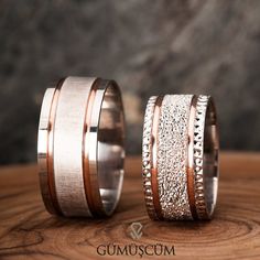 two wedding bands with white and rose gold inlays on top of each other