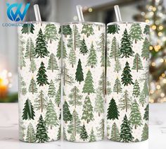 three green and white christmas trees printed on two different colored tumblers, one in the foreground